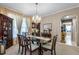 Formal dining room featuring a glass-top table and elegant wooden chairs at 3898 Beacon Ridge Way, Clermont, FL 34711