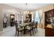 Formal dining room with a glass-top table, crystal chandelier, and hardwood floors at 3898 Beacon Ridge Way, Clermont, FL 34711