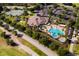 Aerial view of community pool, clubhouse, tennis courts, and parking lot at 3898 Beacon Ridge Way, Clermont, FL 34711