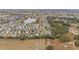 Aerial view of community with houses, landscape, and a lake in background at 392 Arbella Loop, The Villages, FL 32162