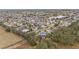 Aerial view of homes in a neighborhood near a lake and open space at 392 Arbella Loop, The Villages, FL 32162