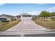 House exterior, showcasing a paver driveway and well-maintained lawn at 392 Arbella Loop, The Villages, FL 32162