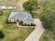 Aerial view of a single-story house showcasing landscaping, circular driveway and proximity to the golf course and water views at 39656 Harbor Hills Blvd, Lady Lake, FL 32159