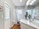 Well-lit bathroom with tub, shower, white vanity, and door to the backyard at 39656 Harbor Hills Blvd, Lady Lake, FL 32159