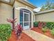 Close-up of a charming front porch featuring a screened entryway, landscaped garden beds, and a well-maintained walkway at 39656 Harbor Hills Blvd, Lady Lake, FL 32159