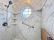 Detailed view of shower with round window, marble tile and built-in shelves at 39656 Harbor Hills Blvd, Lady Lake, FL 32159