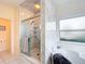 Close-up of the glass-enclosed shower with marble tile and built-in shelving at 39656 Harbor Hills Blvd, Lady Lake, FL 32159