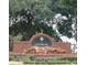 Harbor Hills entrance sign featuring brickwork, stone accents, and lush landscaping at 39656 Harbor Hills Blvd, Lady Lake, FL 32159