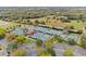 Aerial view of multiple tennis courts surrounded by trees and parking at 39656 Harbor Hills Blvd, Lady Lake, FL 32159