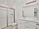 Bathroom with shower, double vanity, and white cabinets at 40210 Orange Cir, Lady Lake, FL 32159