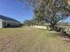 Spacious backyard with mature trees and grassy area at 409 Silver Maple Rd, Groveland, FL 34736