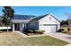 Beautiful single-story home boasting solar panels, a brick driveway, and a lush lawn at 409 Silver Maple Rd, Groveland, FL 34736