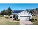 Gray house with solar panels, brick driveway, and landscaped yard at 409 Silver Maple Rd, Groveland, FL 34736