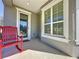 Red rocking chair on porch with glass front door and window at 409 Silver Maple Rd, Groveland, FL 34736