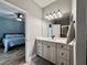 Bathroom with vanity, mirror, and shower; view of bedroom in background at 41913 Cassia St, Eustis, FL 32736