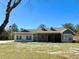 Ranch style home with screened porch, gray brick, and landscaped yard at 41913 Cassia St, Eustis, FL 32736