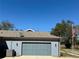 Attached two-car garage with gray doors and a concrete driveway at 41913 Cassia St, Eustis, FL 32736