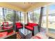 Relaxing screened porch with red wicker furniture and a glass-top coffee table at 4992 Big Cypress St, Oxford, FL 34484