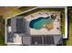 Aerial view of a home with a freeform pool and spa, surrounded by a paved patio at 5055 County Road 125 # B1, Wildwood, FL 34785