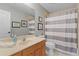 Clean bathroom with striped shower curtain and wood vanity at 5055 County Road 125 # B1, Wildwood, FL 34785