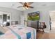 Bright bedroom featuring a large TV and comfortable bedding at 5055 County Road 125 # B1, Wildwood, FL 34785