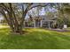 Gray house exterior with large oak tree and manicured lawn at 5055 County Road 125 # B1, Wildwood, FL 34785