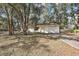 House exterior surrounded by lush trees and a driveway at 5870 Se 158Th Ct, Ocklawaha, FL 32179