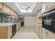 Kitchen with light wood cabinets, black appliances, and a skylight at 5938 Marlberry Dr, Orlando, FL 32819