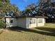 Side view of a ranch home with mature trees at 609 Scenic St, Leesburg, FL 34748