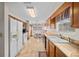 Galley kitchen features tile flooring, white appliances, and a breakfast nook with a ceiling fan at 7 Ginger Cir, Leesburg, FL 34748