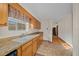 Galley kitchen boasts granite countertops, wooden cabinets, tile flooring, and a double sink at 7 Ginger Cir, Leesburg, FL 34748