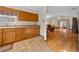 Open layout, view of kitchen with wooden cabinets, countertop, and view to the sunny living room at 7 Ginger Cir, Leesburg, FL 34748