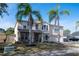 Two-story house with tan exterior, two-car garage, and palm trees at 702 Skyridge Rd, Clermont, FL 34711