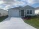 Newly constructed home with a white garage door and landscaping at 7268 Annison Ter, The Villages, FL 32163