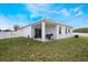 Covered patio, grassy yard, and white vinyl fence at 742 Franklin Ct, Haines City, FL 33844