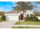 White house with brown door, two-car garage, and landscaping at 742 Franklin Ct, Haines City, FL 33844