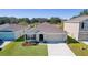 One-story house with a two-car garage and landscaping, wider aerial view at 8661 Triumph Cir, Wildwood, FL 34785