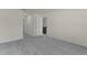 Spacious bedroom with grey carpet and access to a nearby bathroom at 8661 Triumph Cir, Wildwood, FL 34785