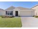 One-story house with a front yard and driveway at 8661 Triumph Cir, Wildwood, FL 34785