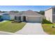 One-story house with a front yard and driveway at 8661 Triumph Cir, Wildwood, FL 34785