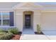 Dark brown front door with sidelights and shutters at 8661 Triumph Cir, Wildwood, FL 34785