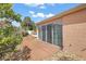 Backyard concrete patio and decorative rock features with sliding glass doors into home at 878 Oviedo Rd, The Villages, FL 32159