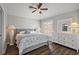 Bedroom with wood floors, ceiling fan, neutral paint, and dresser with lamps at 878 Oviedo Rd, The Villages, FL 32159