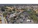 An aerial view shows the neighborhood clubhouse, tennis courts, and pool at 878 Oviedo Rd, The Villages, FL 32159