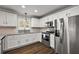 A modern kitchen with white cabinetry, stainless steel appliances, and granite countertops at 878 Oviedo Rd, The Villages, FL 32159