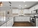 Bright kitchen featuring white cabinets, modern appliances, granite countertops, and wood flooring at 878 Oviedo Rd, The Villages, FL 32159