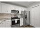 Well-lit kitchen with stainless steel appliances and white cabinetry at 878 Oviedo Rd, The Villages, FL 32159