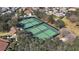 Overhead view of well-maintained tennis courts nestled within a vibrant residential area at 878 Oviedo Rd, The Villages, FL 32159