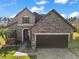 Two-story home with stone accents and a three-car garage at 9277 Sw 70Th Loop, Ocala, FL 34481