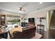 Bright living room featuring hardwood floors, a large TV, and sliding glass doors opening to a pool view at 9277 Sw 70Th Loop, Ocala, FL 34481